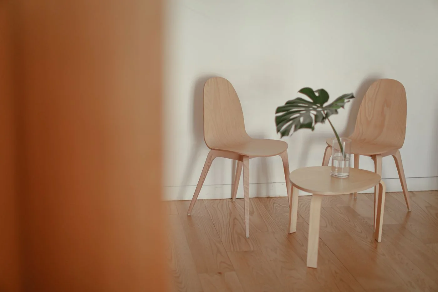 A minimalist interior with two wooden chairs and table showcasing simple elegance.