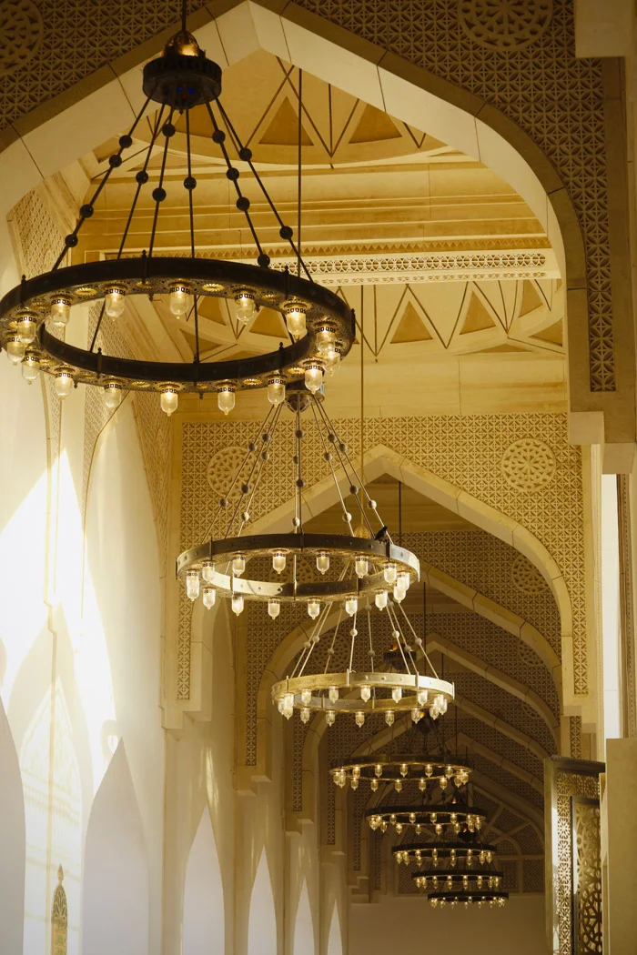 Elegant corridor featuring ornate chandeliers in a grand palace interior.