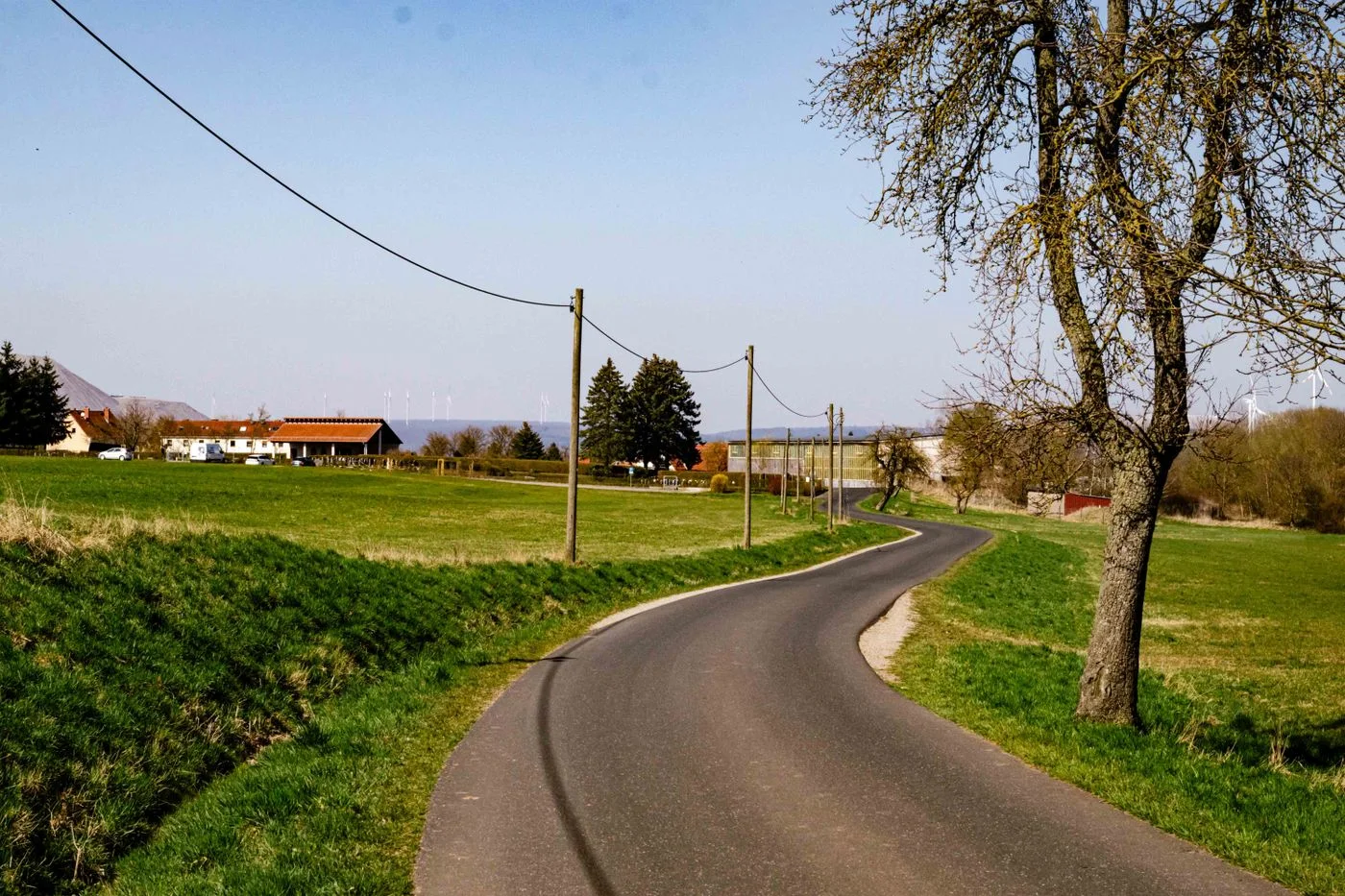 A peaceful winding road through a lush rural landscape on a sunny day, ideal for outdoor relaxation.