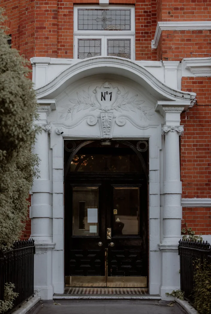 Elegant Victorian entrance of a brick building in London with classic architectural details.