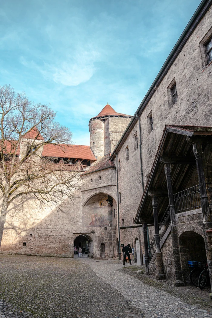Explore the historic charm of a medieval castle courtyard with stone walls and towers.