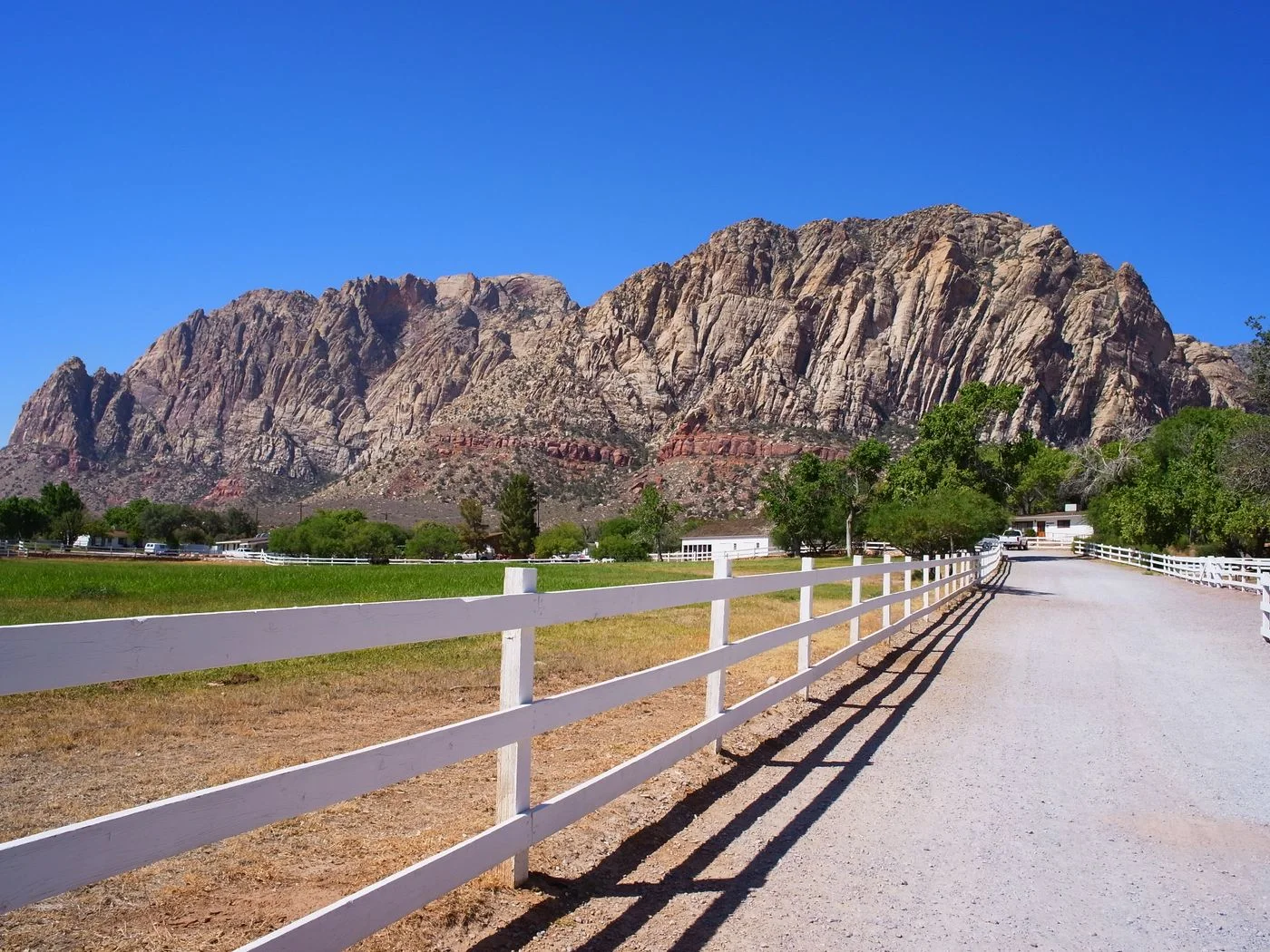 Capture of a serene ranch with white fence against the Red Rock Canyon mountains near Las Vegas.