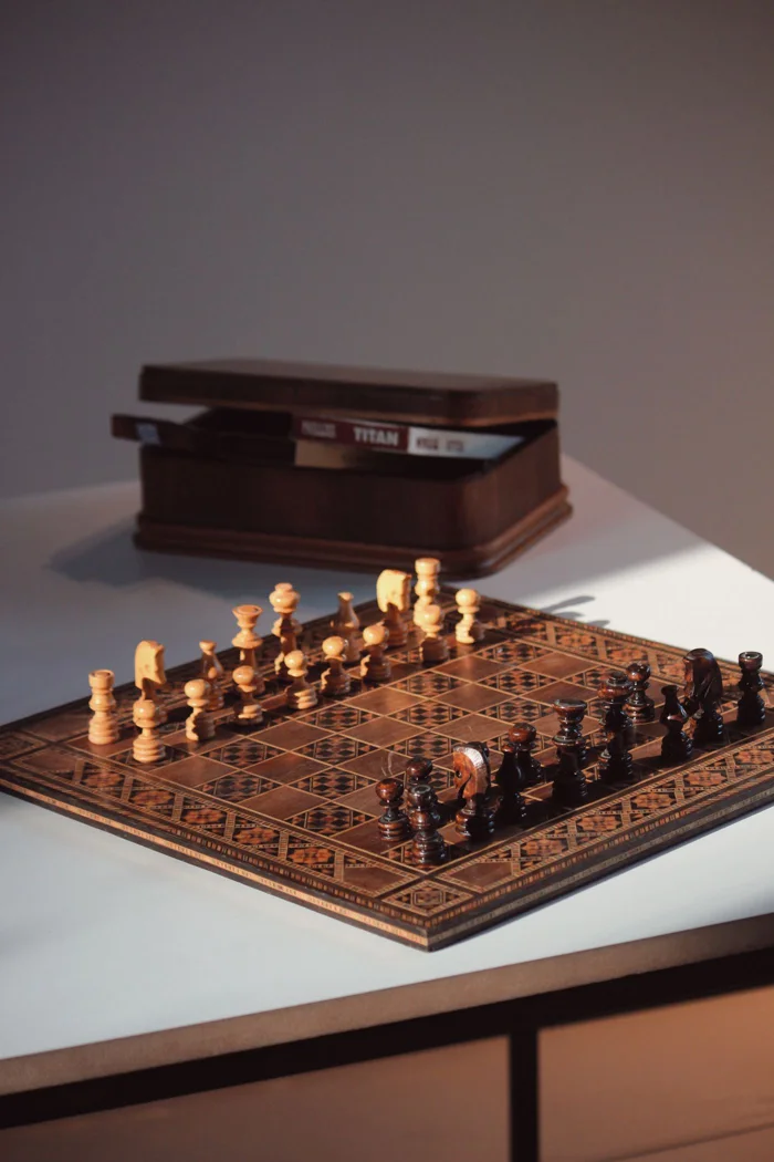 High-quality photo of a wooden chessboard with pieces, bathed in warm sunlight on a modern table.
