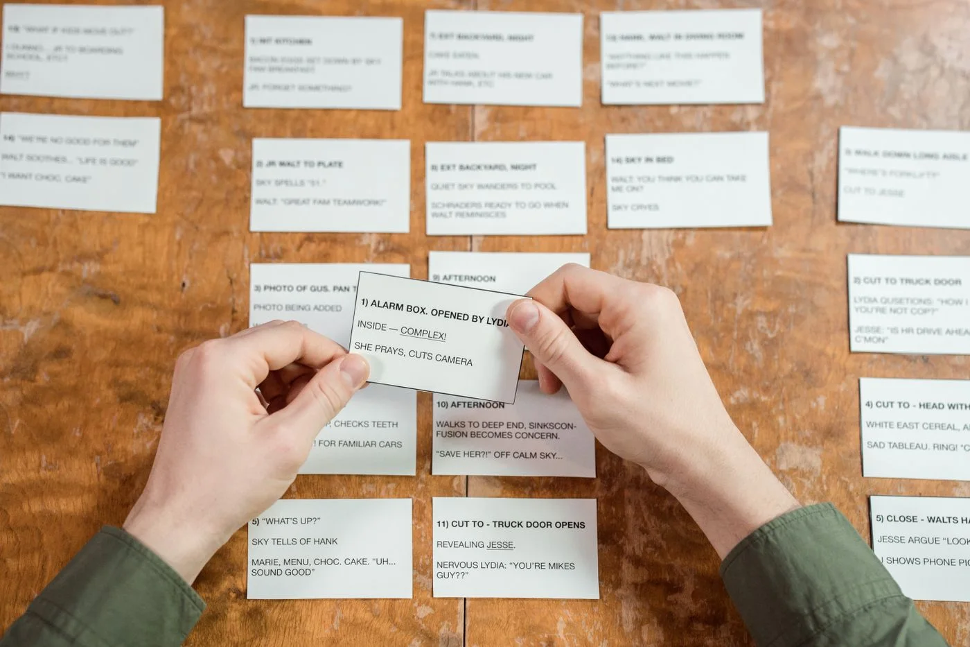 Hands organizing index cards on a desk, focusing on planning, creativity, and workflow strategy.